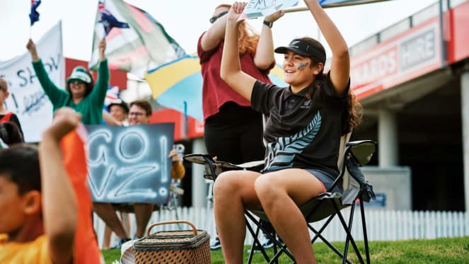 A sports supporter dressed in New Zealand colours cheering