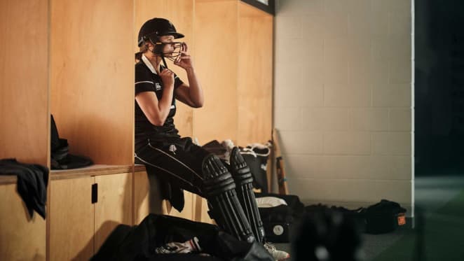 Suzie Bates putting her cricket gear on