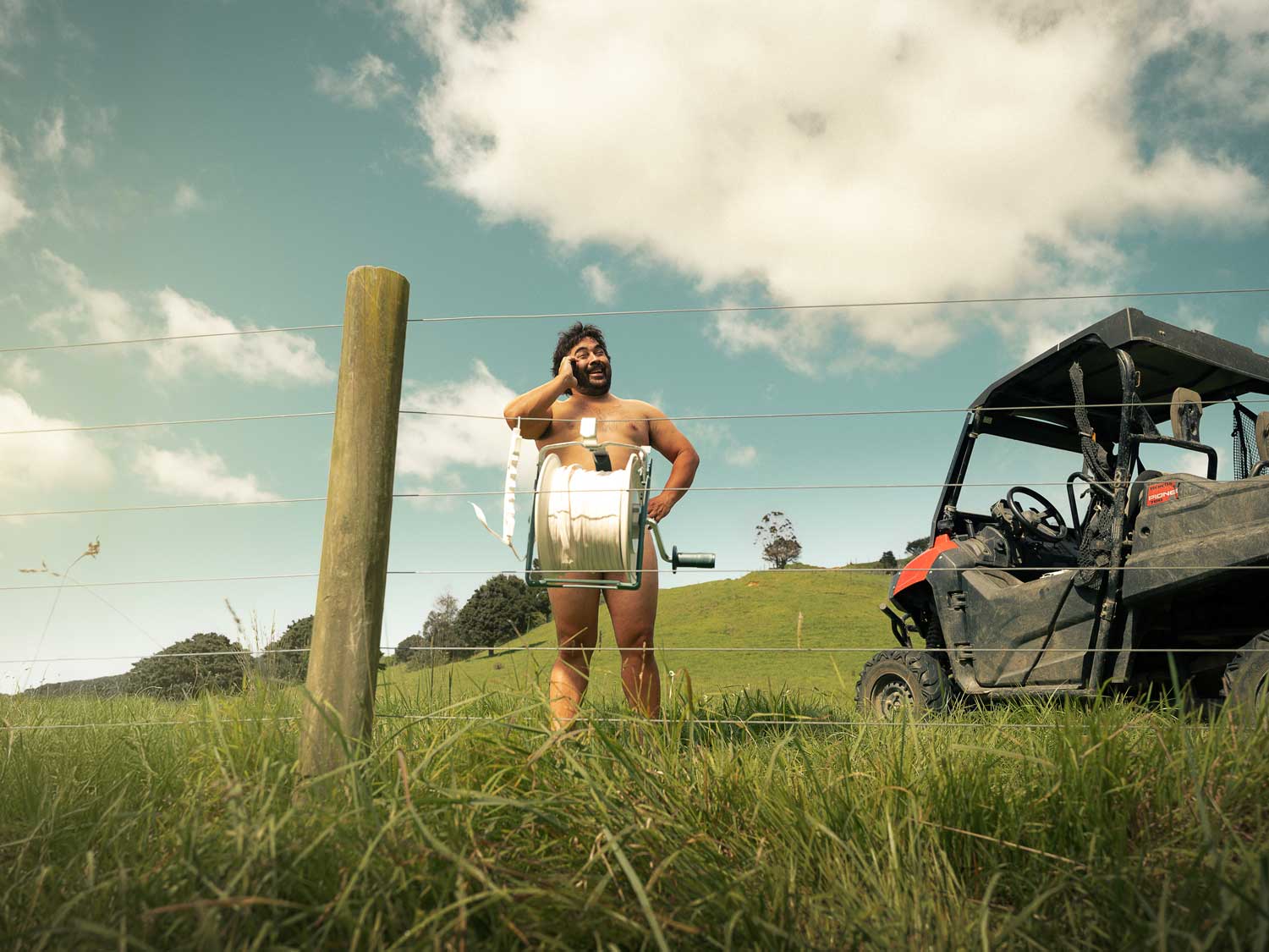 Man on the phone behind a reel of white temporary fence tape