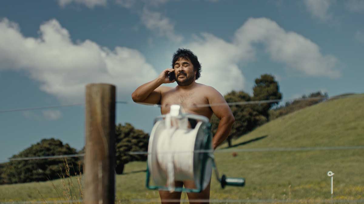 Man on the phone behind a reel of white temporary fence tape