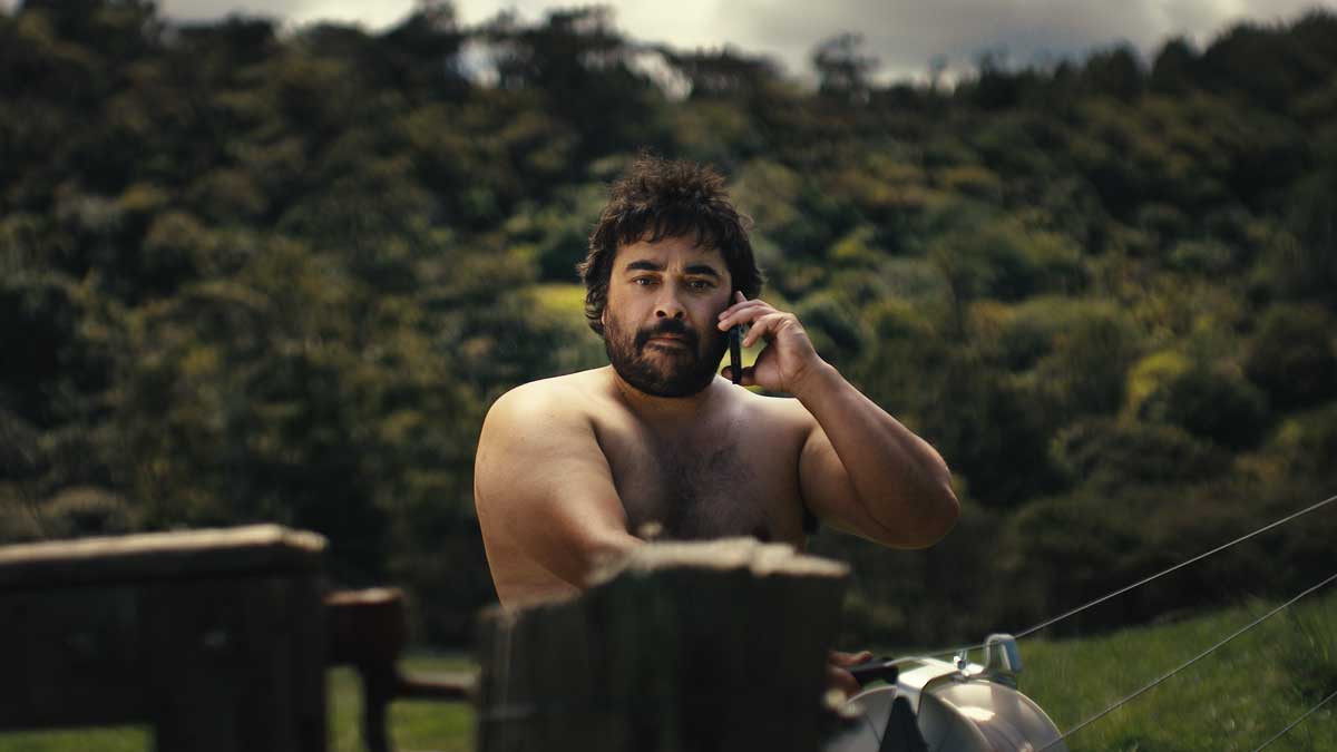 A man on the phone behind a post